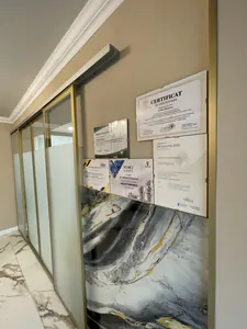 Holul cabinetului, cu certificate pe perete și marmură